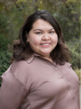 A woman in a brown shirt smiling for the camera.