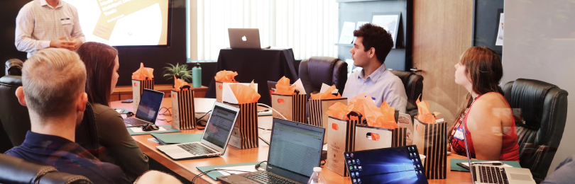 A man sitting at a table with several laptops.